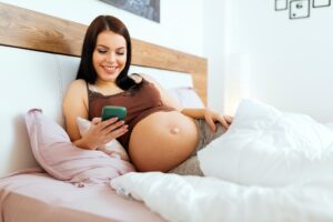 Beautiful pregnant woman using phone