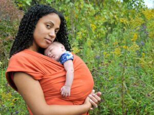Babywearing: una mamma porta il suo bambino al petto sfruttando la fascia