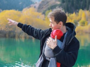 Babywearing: un papà porta il suo bambino al petto con una fascia
